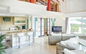 a kitchen and living room with a bar and chairs at Lovely Home In Saint-Pée-Sur-Nivelle in Saint-Pée-sur-Nivelle