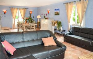 a living room with a leather couch and a dining room at Cozy Home In Payzac With Kitchen in Payzac