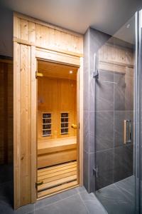a shower with a wooden door in a bathroom at Molo Lipno Apartment C301 Lipno Home in Lipno nad Vltavou