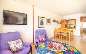 a living room with two purple chairs and a table at Amazing Apartment In Benidorm With Outdoor Swimming Pool, Swimming Pool And 1 Bedrooms in Benidorm