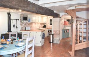 eine Küche mit einem Tisch und einem Herd in der Unterkunft Amazing Home In Lusignac With Outdoor Swimming Pool in Lusignac