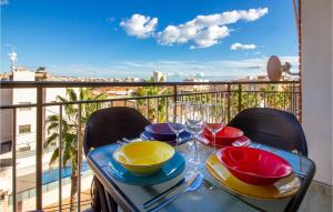 a table with plates and wine glasses on a balcony at Stunning Apartment In Santa Pola in Santa Pola +19 photos