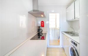 a white kitchen with a sink and a washing machine at Stunning Apartment In Santa Pola in Santa Pola