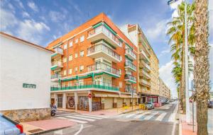 a tall brick building on a street with a palm tree at Stunning Apartment In Santa Pola in Santa Pola