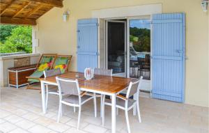 einen Holztisch und Stühle auf einer Terrasse in der Unterkunft Gorgeous Home In Brantme With Outdoor Swimming Pool in Brantôme