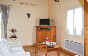 ein Wohnzimmer mit einem TV und einem Couchtisch in der Unterkunft Gorgeous Home In Brantme With Outdoor Swimming Pool in Brantôme