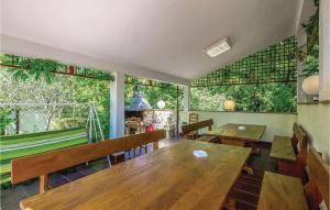 een restaurant met houten tafels en stoelen en grote ramen bij Cozy Apartment In Povile With House A Panoramic View in Povile