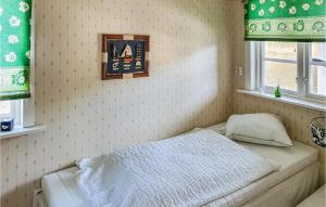 a bedroom with a bed in a corner with two windows at Nice Home In Ljusne With Wifi in Ljusne