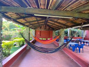 a hammock on a patio with tables and chairs at Finca Villa Chalet Del Rio Cali Farm Villa Chalet Cali River in Cali