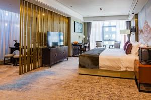 een hotelkamer met een bed en een flatscreen-tv bij LDS Hotel Belgrade in Belgrado