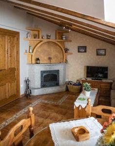ein Wohnzimmer mit einem Tisch und einem Kamin in der Unterkunft El Nido de Gredos cuco apartamento in Navarredonda de Gredos