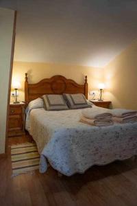 ein Schlafzimmer mit einem großen Bett und zwei Nachttischen in der Unterkunft El Nido de Gredos cuco apartamento in Navarredonda de Gredos