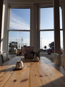 a dining room table with a view of a large window at The Beach Hotel in Minehead