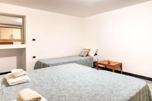 a bedroom with two beds and a couch and a mirror at A casa di Pietro Quattro in Leporano