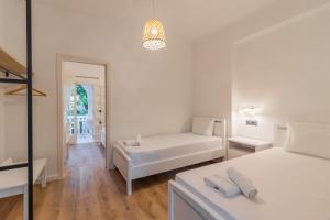 Alamis Hotel & Apartments في تسيليفي: غرفة نوم بيضاء مع سرير وأريكة