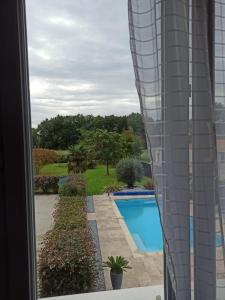 a view of a swimming pool from a window at Magnolia in Trois-Palis