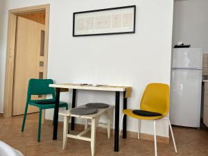 - une table et des chaises dans la cuisine équipée d'un réfrigérateur dans l'établissement Wash House Apartman, à Győr