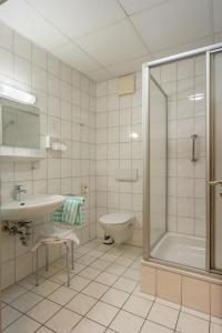 a bathroom with a sink and a shower and a toilet at Hotel Villa Dürkopp in Bad Salzuflen