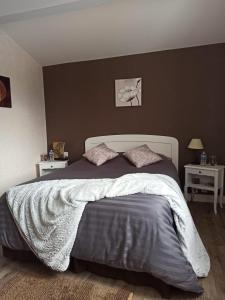 een slaapkamer met een groot bed met 2 nachtkastjes bij Magnolia in Trois-Palis