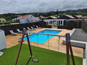 una piscina con un columpio en una casa en As Casas da Vinha en Criação Velha