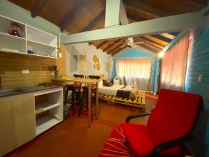 a kitchen with a red chair in a room with a bed at Finca Villa Chalet Del Rio Cali Farm Villa Chalet Cali River in Cali