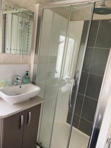a bathroom with a shower and a sink at Sunrise - Beautiful lakeside caravan in South Cerney