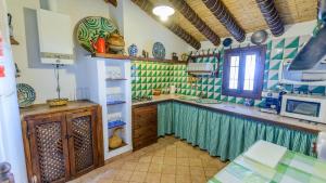 cocina con paredes de azulejos verdes y blancos en El Morrón Algarinejo by Ruralidays en Algarinejo
