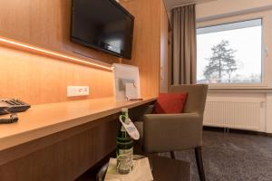 a hotel room with a desk with a bottle of wine at Hotel Villa Dürkopp in Bad Salzuflen
