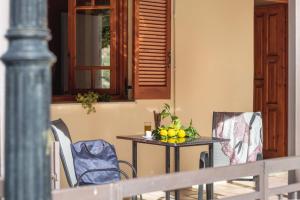 - une table avec un bol de fruits et des chaises sur une terrasse couverte dans l'établissement Krinos apartment 1, 