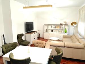 ein Wohnzimmer mit einem Sofa, einem Tisch und Stühlen in der Unterkunft Luxury apartment Podgorica in Podgorica