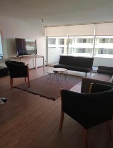 a living room with a couch and chairs and a tv at 22 ,Costado Clinica Las Condes ,6 Personas in Santiago