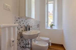 a white bathroom with a sink and a toilet at Città del Capo in Trieste