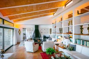 ein Wohnzimmer mit weißen Möbeln und Bücherregalen in der Unterkunft Punta d'en Bailet in Cadaqués