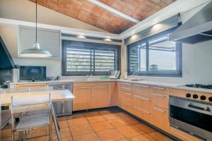 eine große Küche mit einem Holztisch und einer Holzdecke in der Unterkunft Punta d'en Bailet in Cadaqués