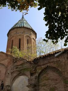 um edifício com uma torre de relógio em cima em 3 Heritage Rooms em Tbilisi