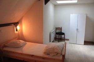 ein Schlafzimmer mit einem Bett und einem Stuhl in der Unterkunft -Le Petit Mouton- Spacieux logement centre ville in Argenton-sur-Creuse
