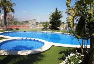 Una gran piscina en medio de un patio. en Cozy bright apartment, en Guardamar del Segura