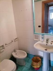 bagno con lavandino, servizi igienici e specchio di Atlantic Ostello B&B a Napoli