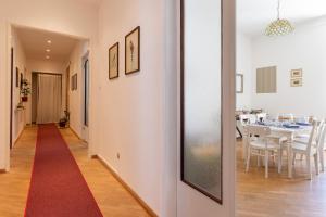 得利雅斯特的住宿－Città del Capo，走廊通往铺有红地毯的用餐室