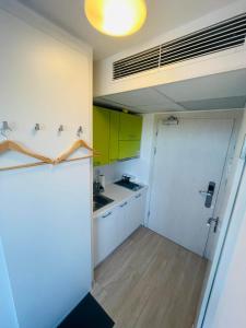 a small kitchen with white cabinets and a yellow door at Studio 88 in Wrocław