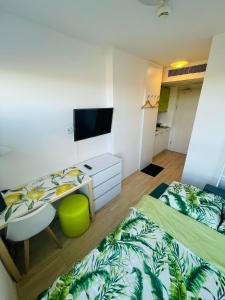 a bedroom with two beds and a desk and a tv at Studio 88 in Wrocław