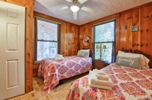 a bedroom with two beds and wooden walls at Dancing Waters in Lake Lure