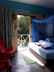 sypialnia z łóżkiem, krzesłem i oknem w obiekcie Tahan Guest House w mieście Kuala Tahan