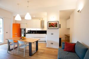 eine Küche und ein Wohnzimmer mit einem Tisch und einem Sofa in der Unterkunft Fleming Magnolia, confortevole open space in Rom