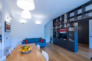 uma sala de estar com uma mesa e um sofá azul em Fleming Magnolia, confortevole open space em Roma