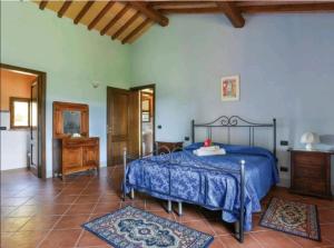 1 dormitorio con 1 cama azul y 2 alfombras en Il Nido country house, en Montaione