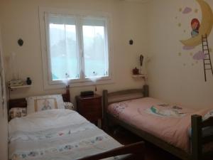 dwa łóżka pojedyncze w pokoju z oknem w obiekcie les petites roches w mieście Saint-Fortunat-sur-Eyrieux