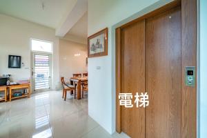 um quarto com uma porta de madeira e uma sala de jantar em 馬在對面民宿 em Yilan City