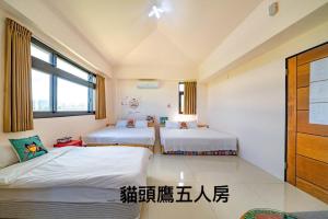 a bedroom with two beds and a window at 馬在對面民宿 in Yilan City