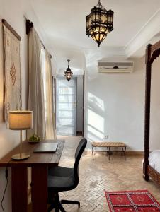 una habitación con un escritorio, una silla y una lámpara en Outsite Marrakesh, en Marrakech